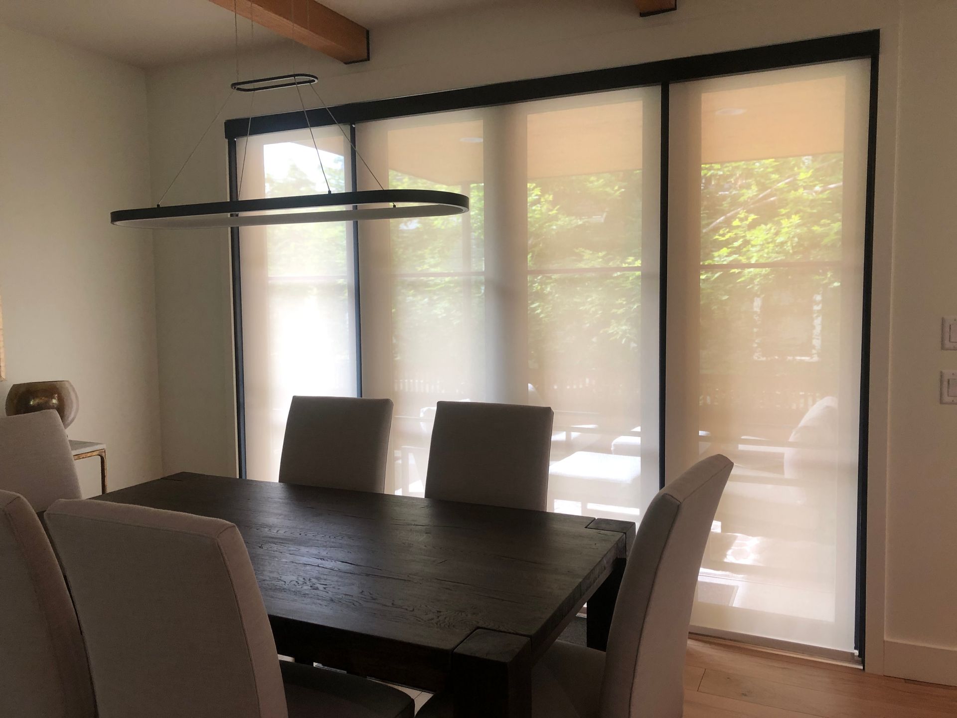 A dining room with a table and chairs and sliding glass doors.