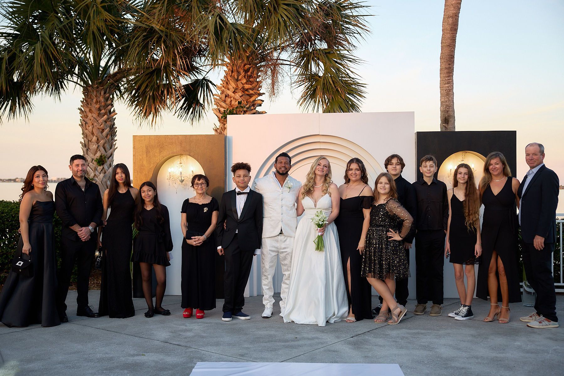 A group of people are posing for a picture at a wedding.