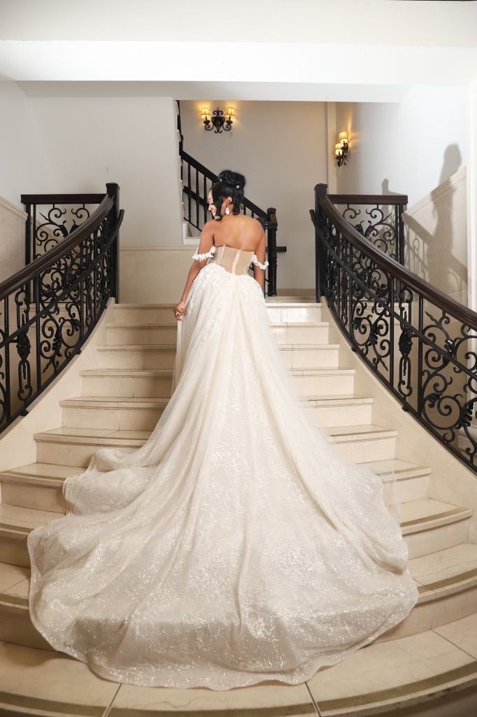 A woman in a wedding dress is walking down a set of stairs.