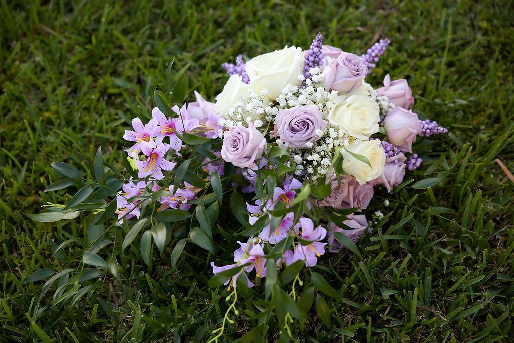 Bouquet of lavender and white flowers on green grass.