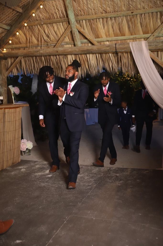 A group of men in suits and bow ties are dancing in a room.
