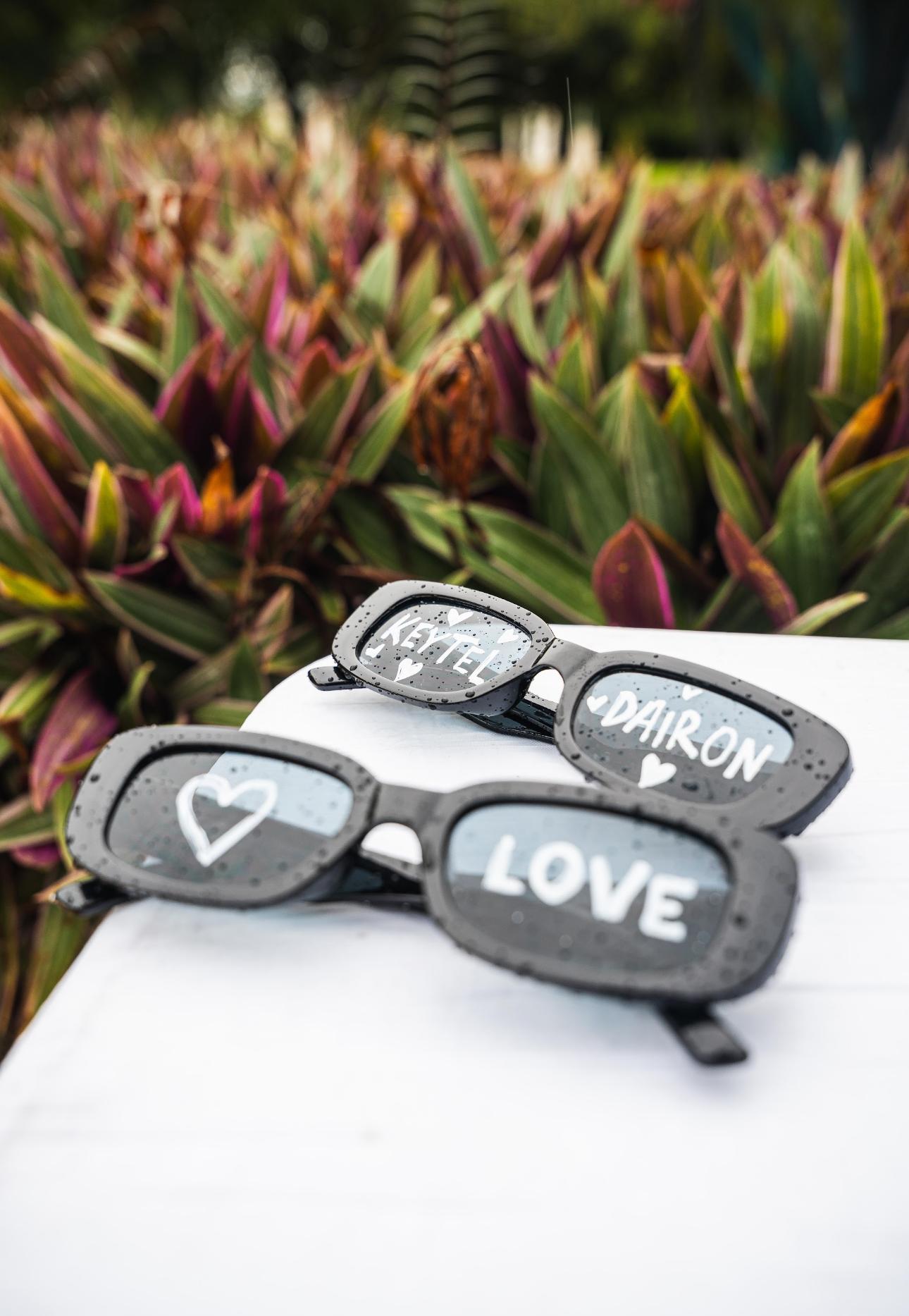 Two sunglasses on a white surface, with 