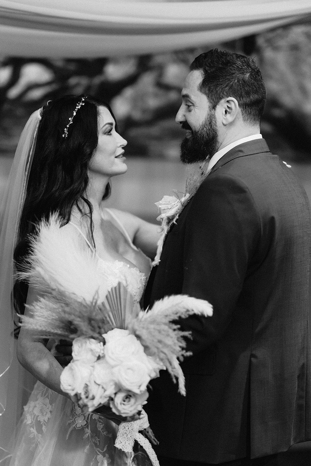 A black and white photo of a bride and groom looking at each other.