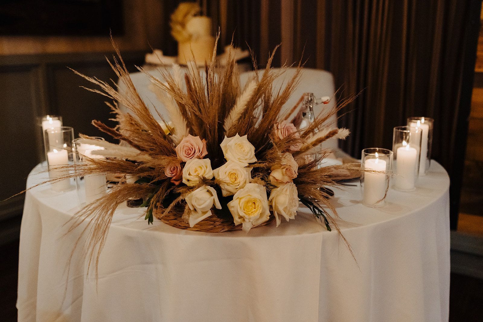 A table with a bouquet of flowers and candles on it.
