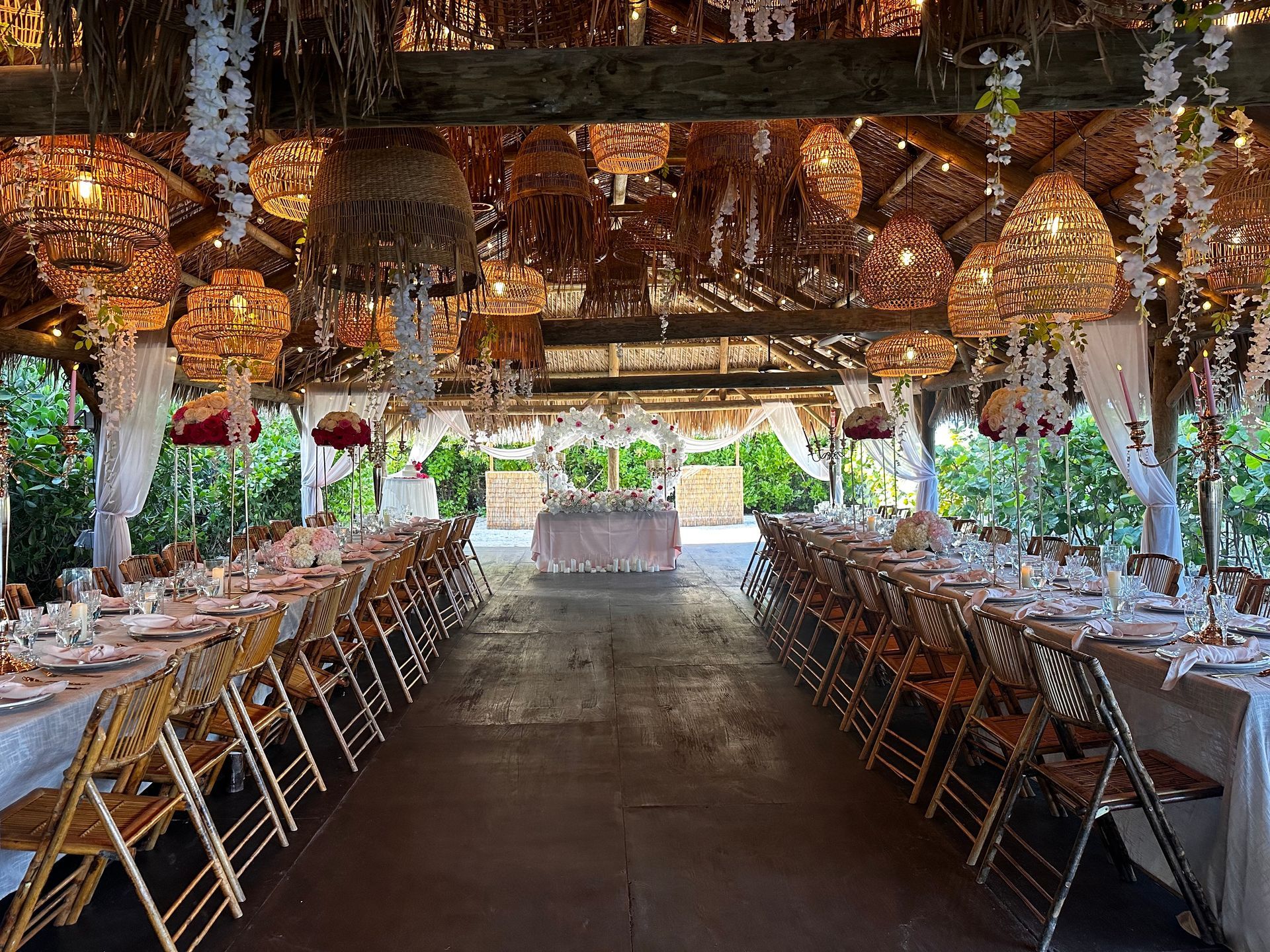 A long dining room with tables and chairs set up for a wedding reception.