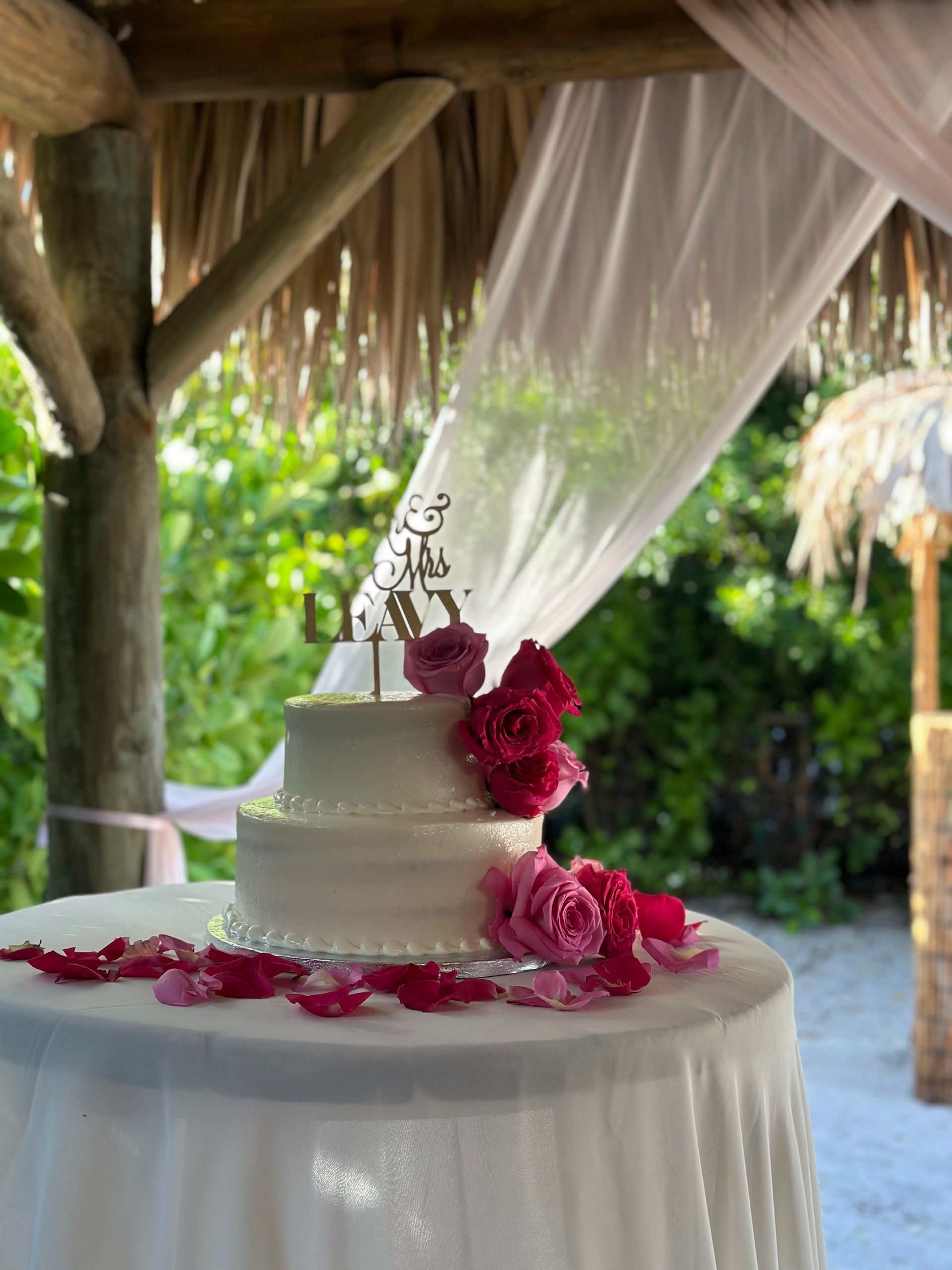 A wedding cake is sitting on a table under a canopy