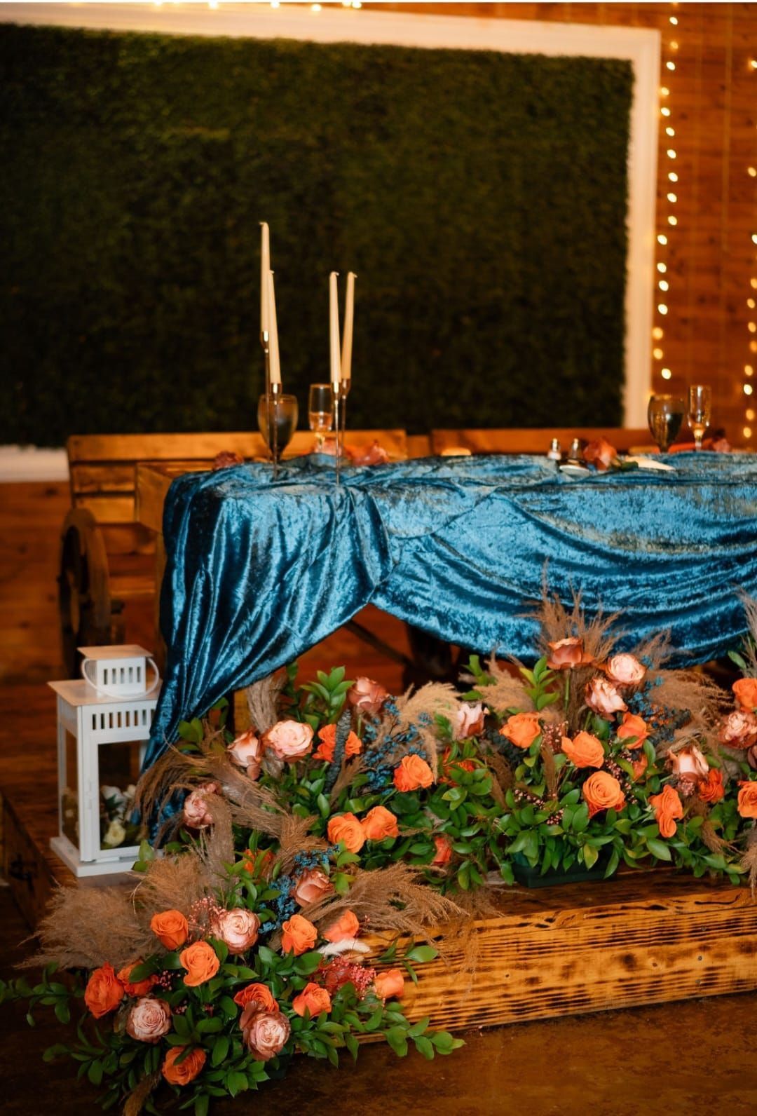 A table with a blue table cloth and flowers on it.