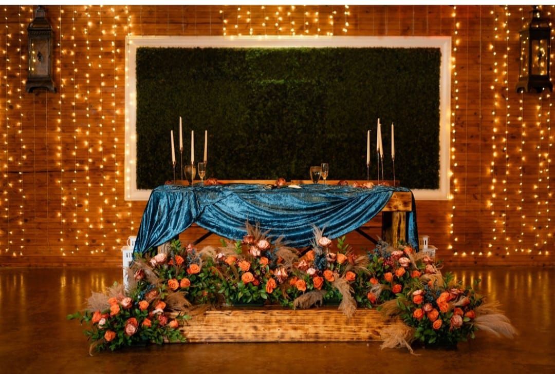 A table with candles and flowers in front of a wall with lights.
