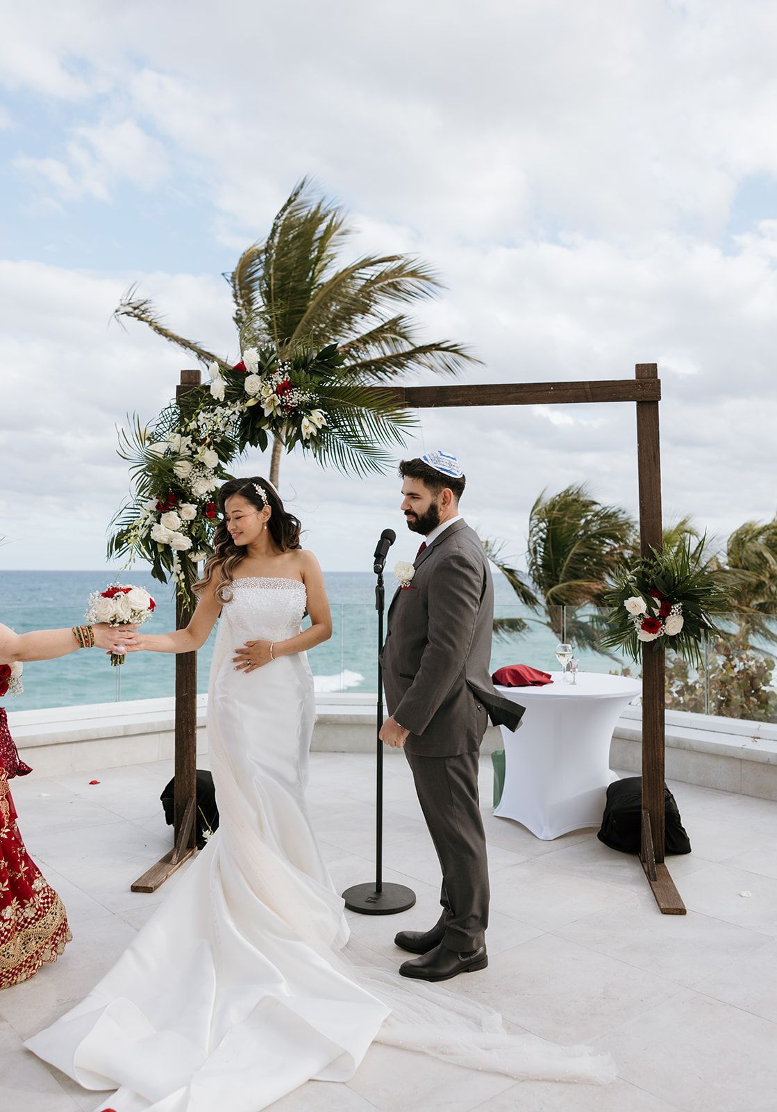A bride and groom are standing in front of a microphone during their wedding ceremony.