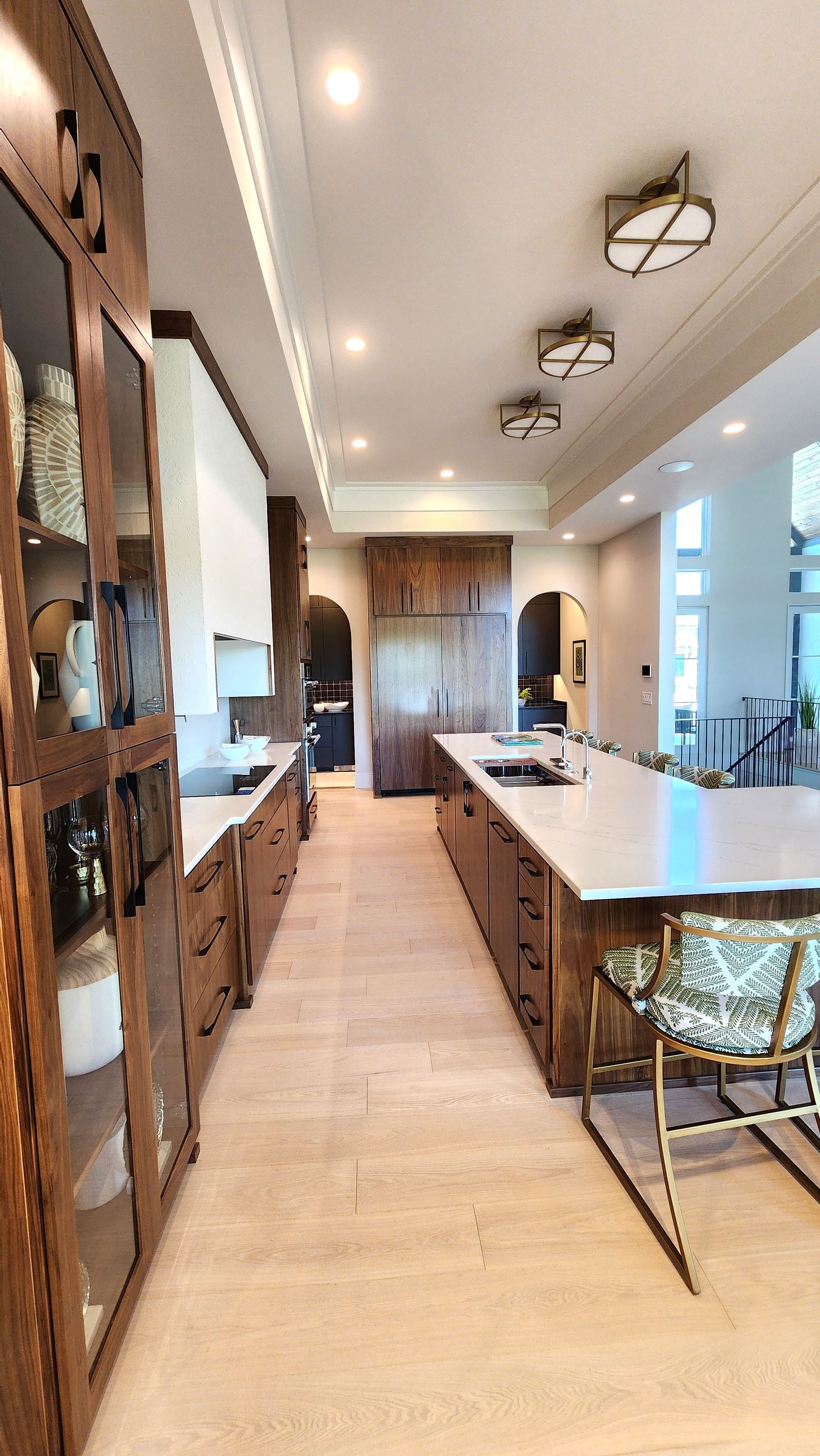 A long hallway leading to a kitchen with a large island in the middle.