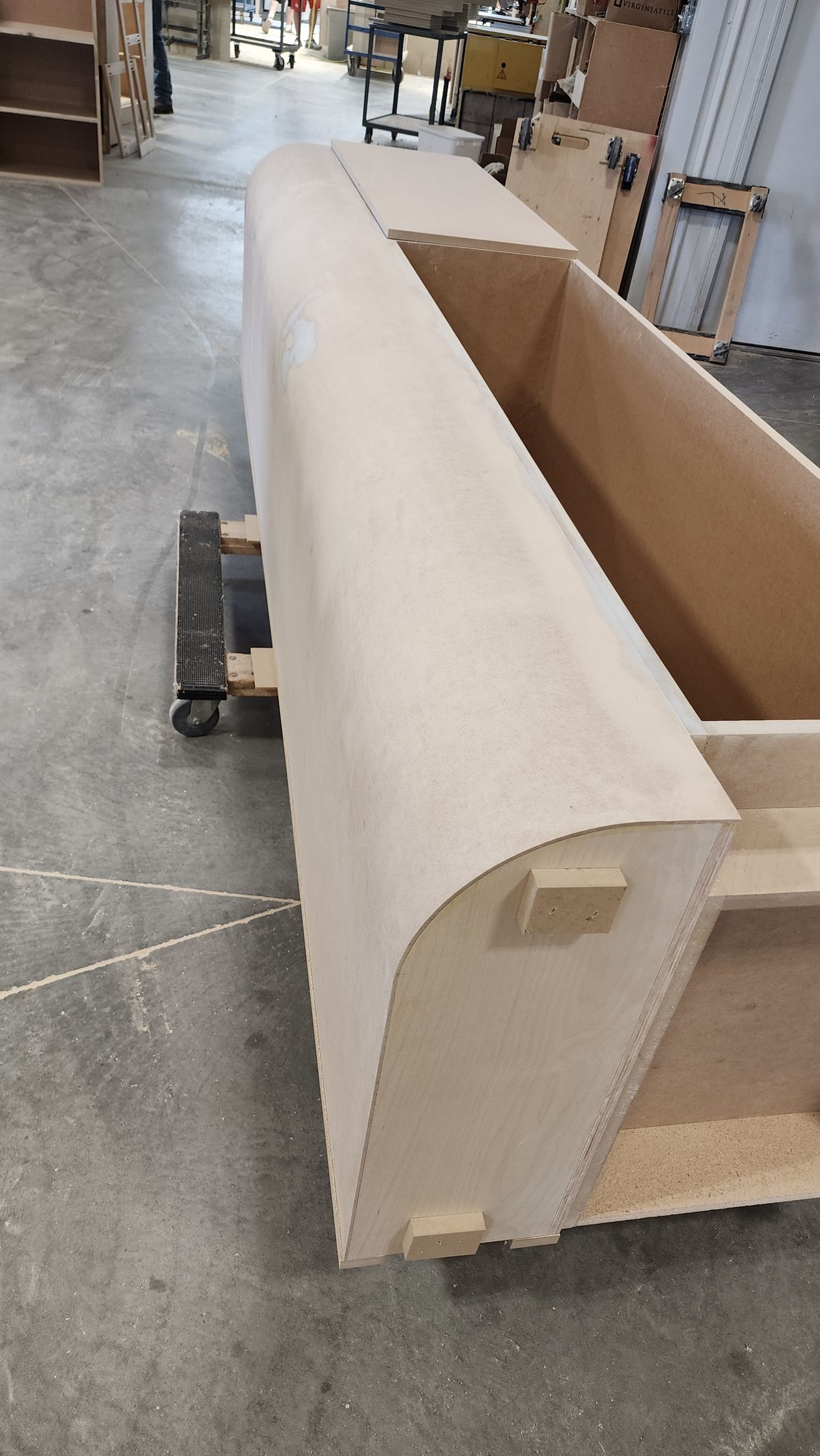 A large piece of wood is sitting on the floor in a warehouse.