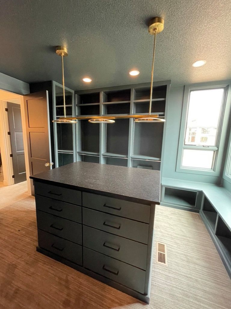 A walk in closet with a large island in the middle of the room.