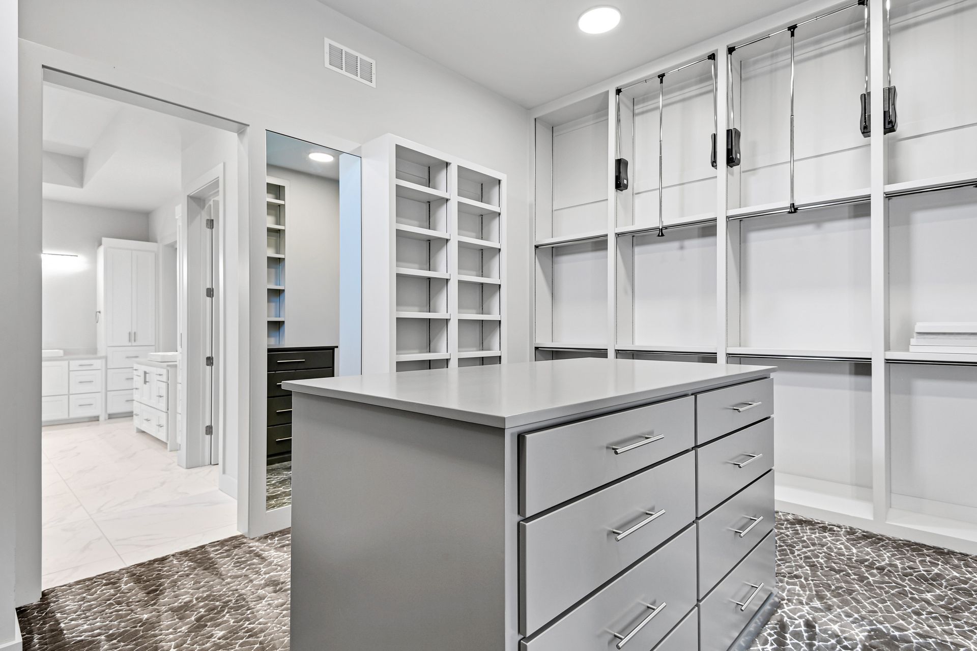 A walk in closet with a large island in the middle.