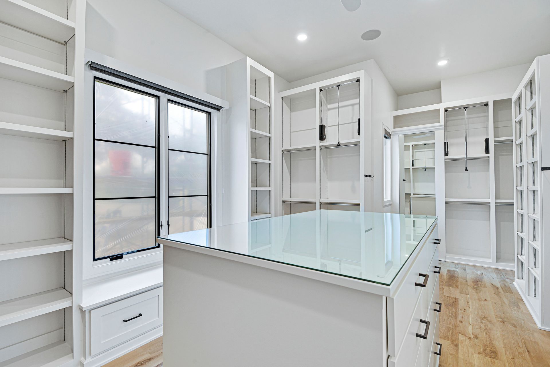 There is a large walk in closet with lots of shelves and drawers.