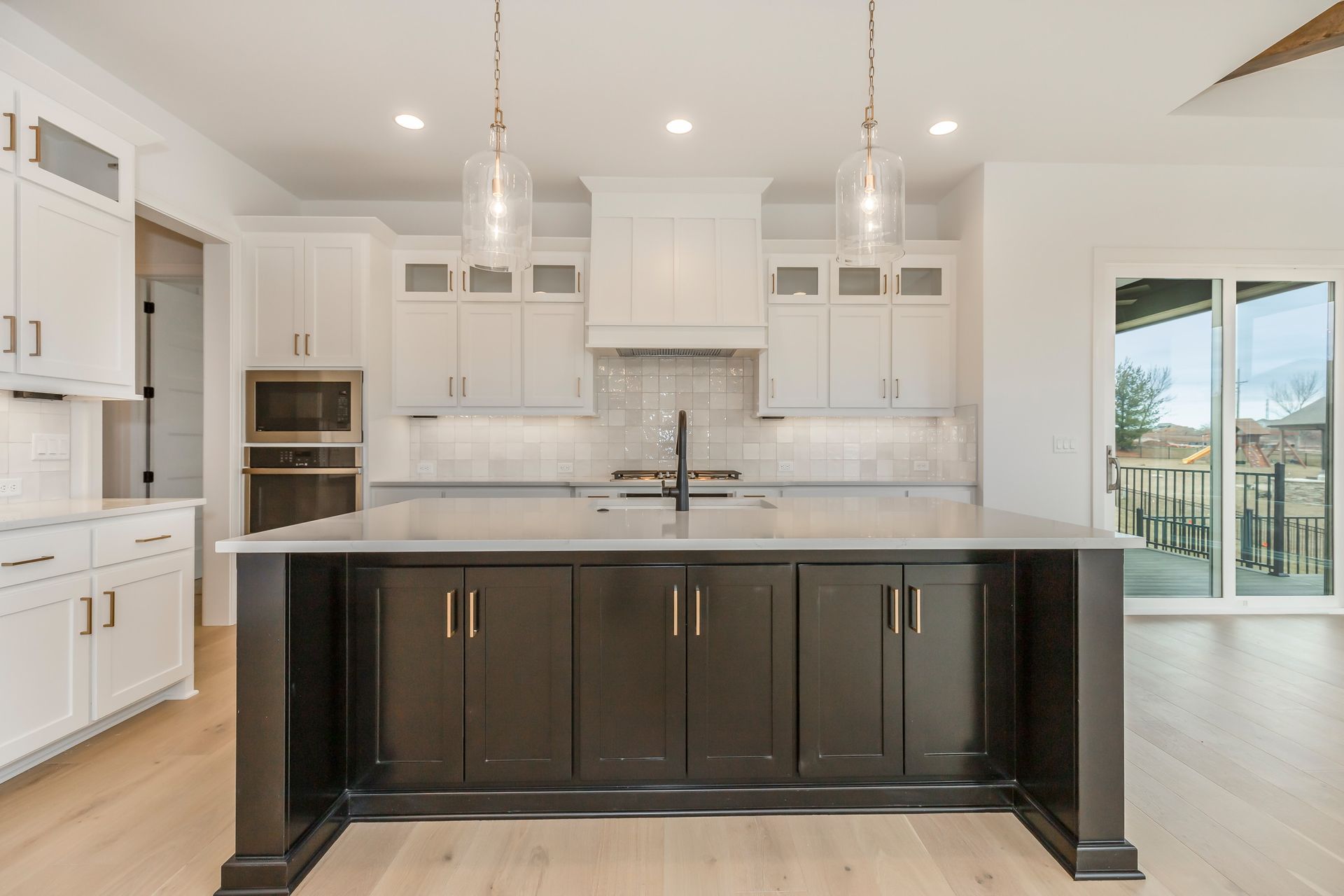 A kitchen with white cabinets and a large island in the middle.