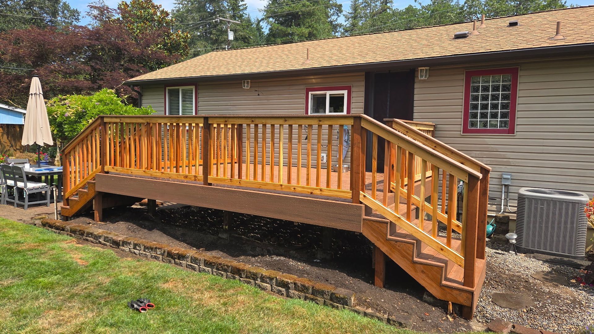 Wooden accessibility ramp with railings beside a house, leading to a raised deck.