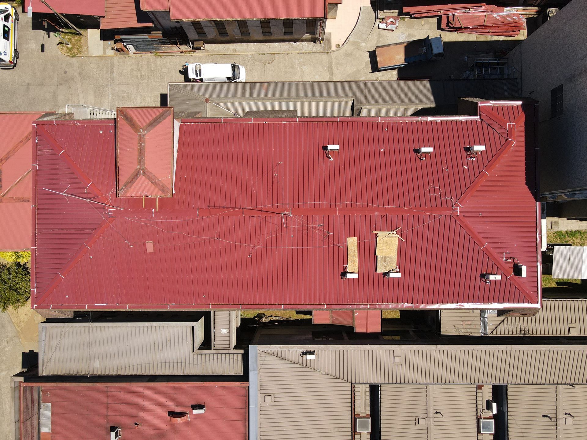 Aerial view of a large red-roofed building surrounded by smaller structures.