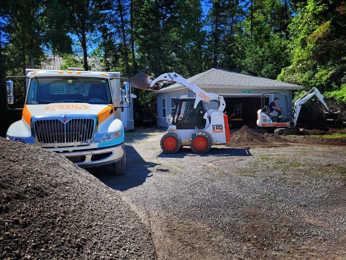 bobcat and excavator moving dirt for landscaping