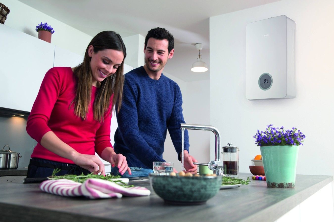 famiglia felice in cucina con scaldabagno a gas nello sfondo