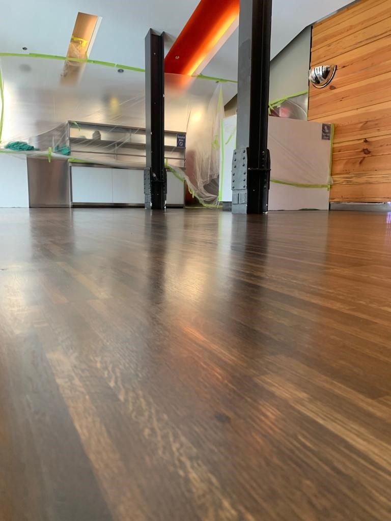 a wooden floor in a room with a shelf in the background .