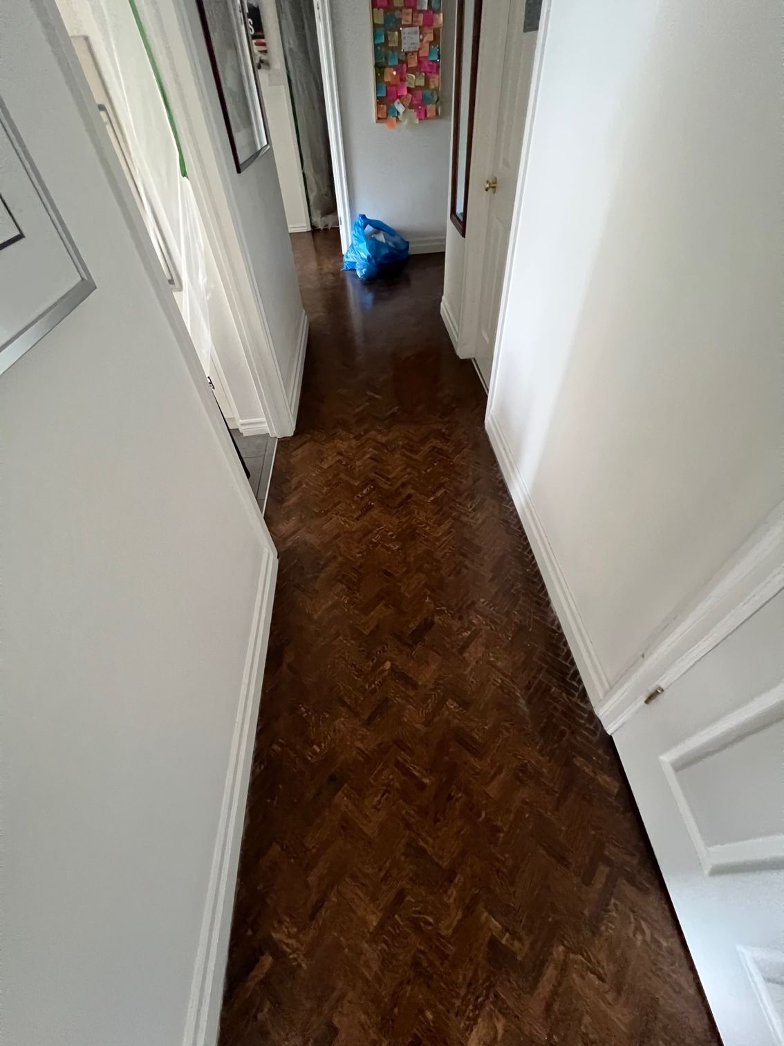 A hallway with a wooden floor and white walls