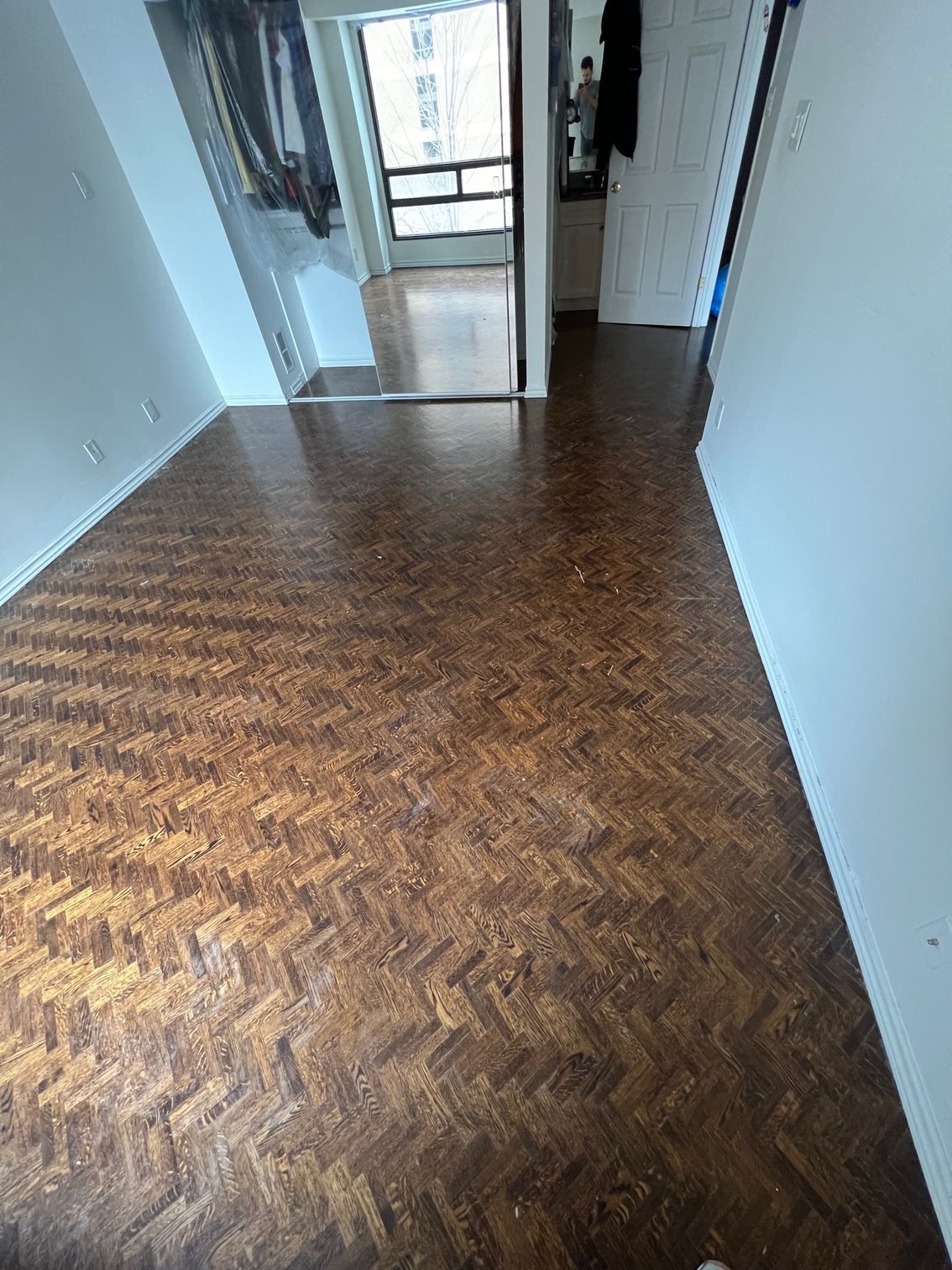 A room with a wooden floor and a mirror.