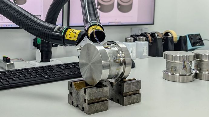 A load cell being manufactured and strain gauged.