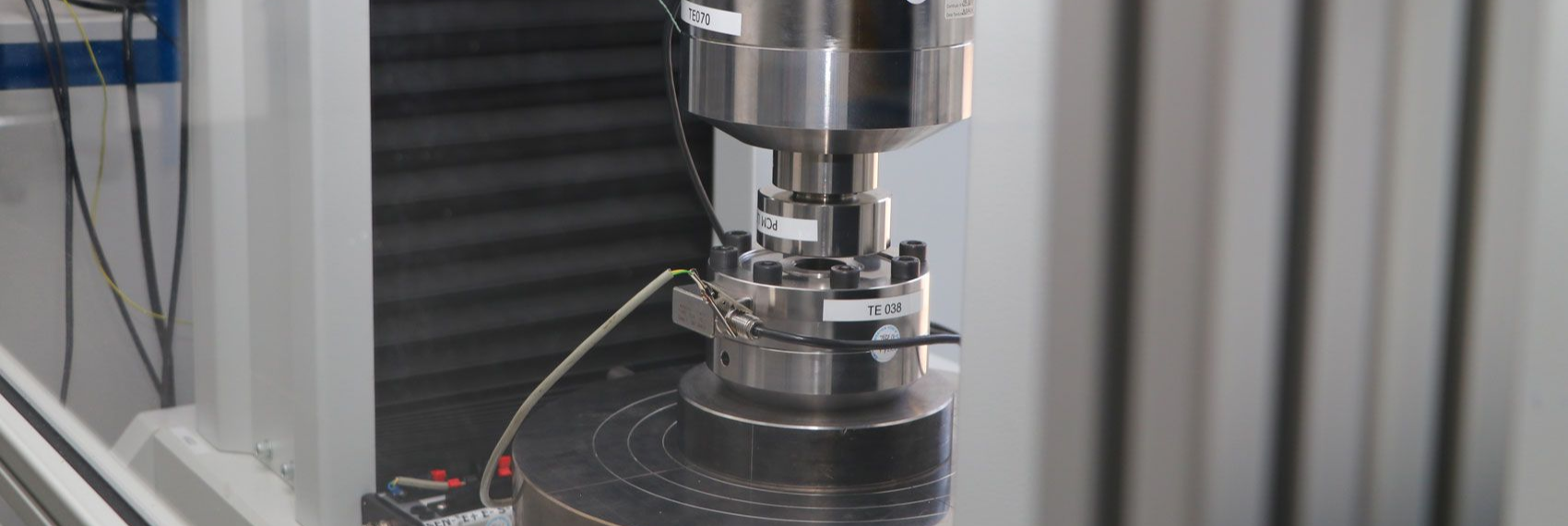 A single compression load cell being calibrated to UKAS 17025 in a test rig.