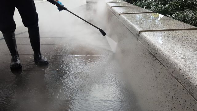 A Person in Black Rain Boots Uses a Pressure Washer — South Coast Pressure Washer in Warilla, NSW
