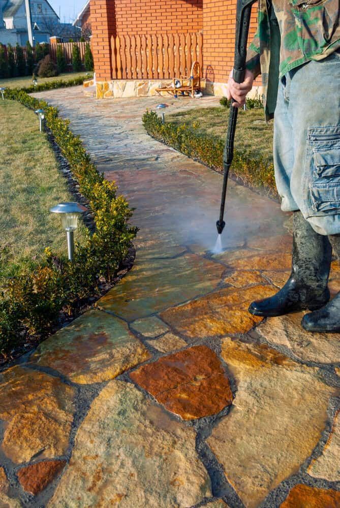 A Person Power-washing a Stone Walkway — South Coast Pressure Washer in Kiama, NSW