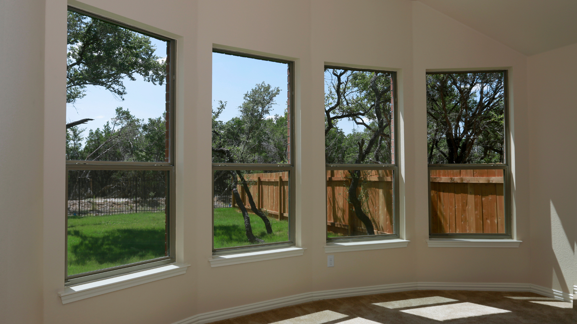 A room with a lot of windows and a fence in the background
