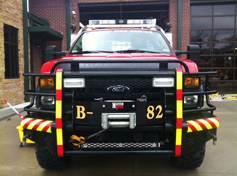 A red brush fire truck with the number 82 on the front bumper