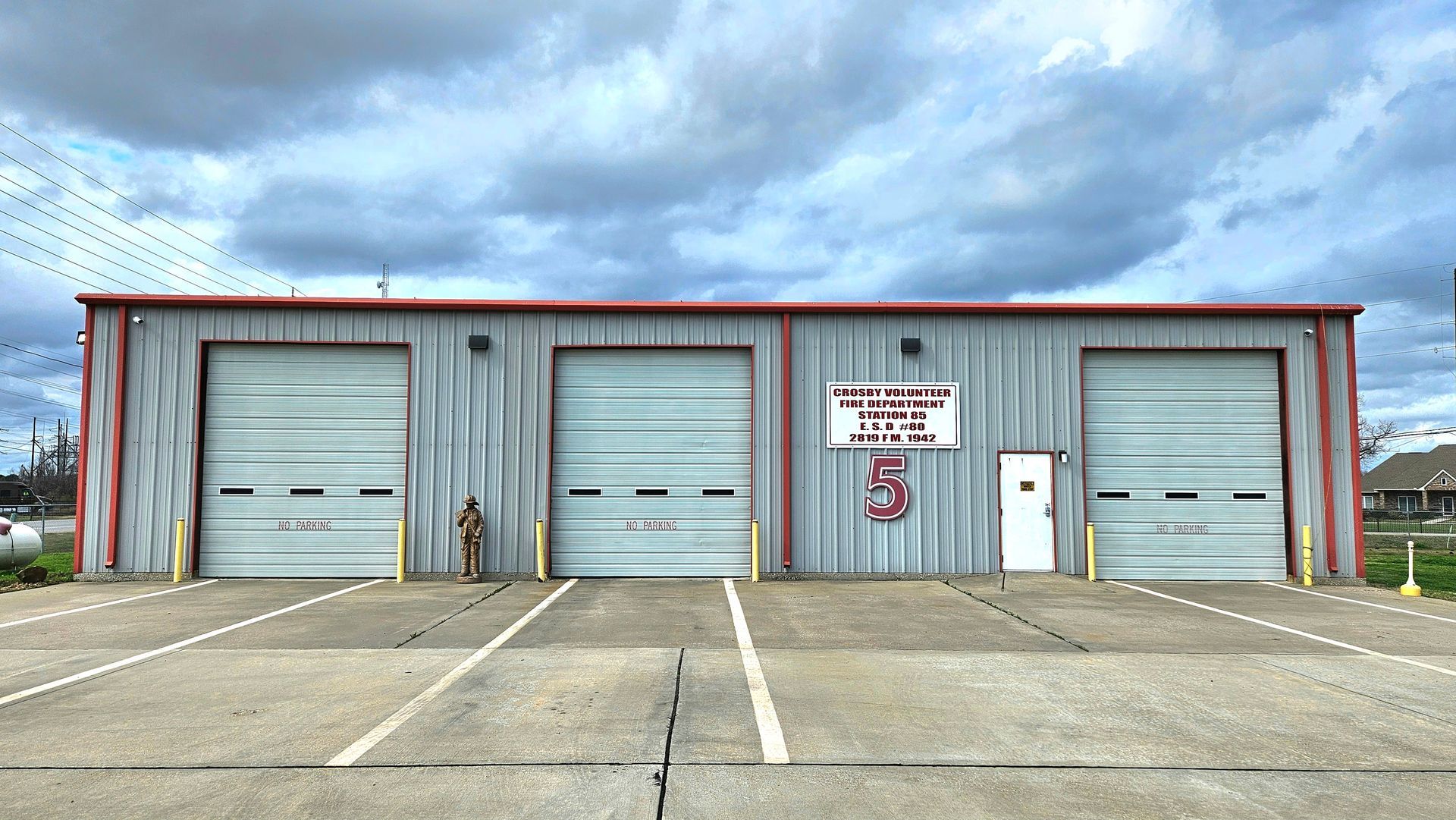 A fire station with three garage doors and a sign that says 5