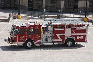 A red fire truck with e-82 on the side is parked in a parking lot