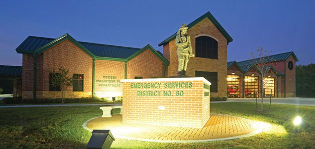 A Crosby VFD fire station with a statue in front of it that says Emergency Services District No. 80