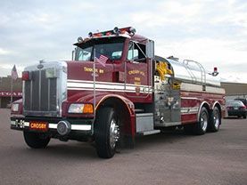 A red and silver fire truck is parked in a parking lot.