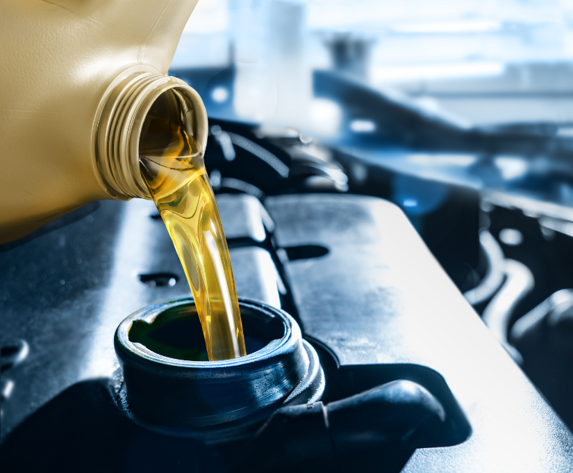 Pouring fresh oil from a yellow container into a car engine.