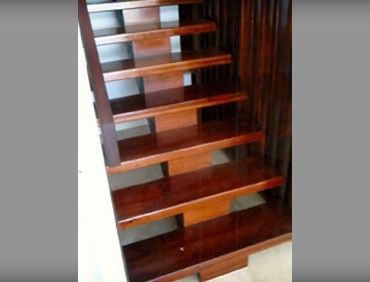 Wooden staircase with dark brown treads and risers.