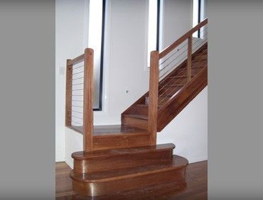 Wooden staircase with cable railing in a modern home.