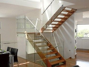 Wooden staircase with glass railing in a modern home.