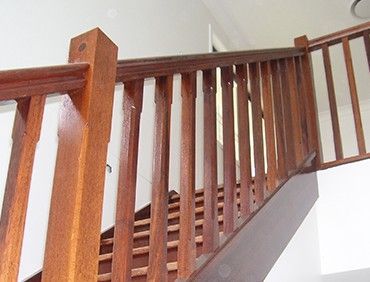 Wooden staircase with brown balusters and handrail.