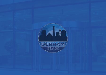 Blue-tinted glass storefront with a circular Durham Glass logo centered on the door.