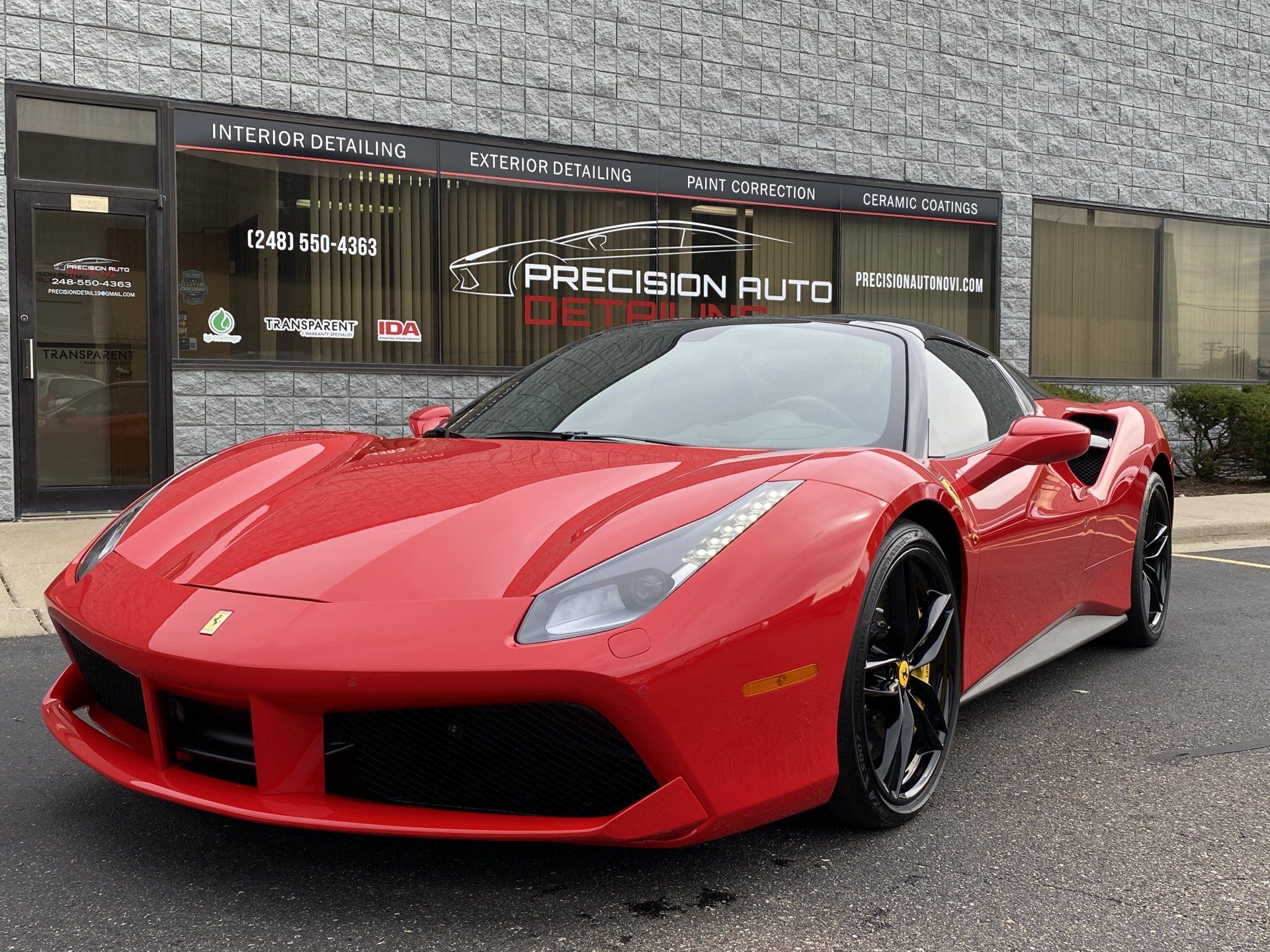 A red sports car is parked in front of a building.