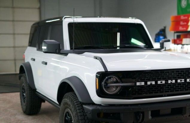 White Ford Bronco with black accents parked inside.