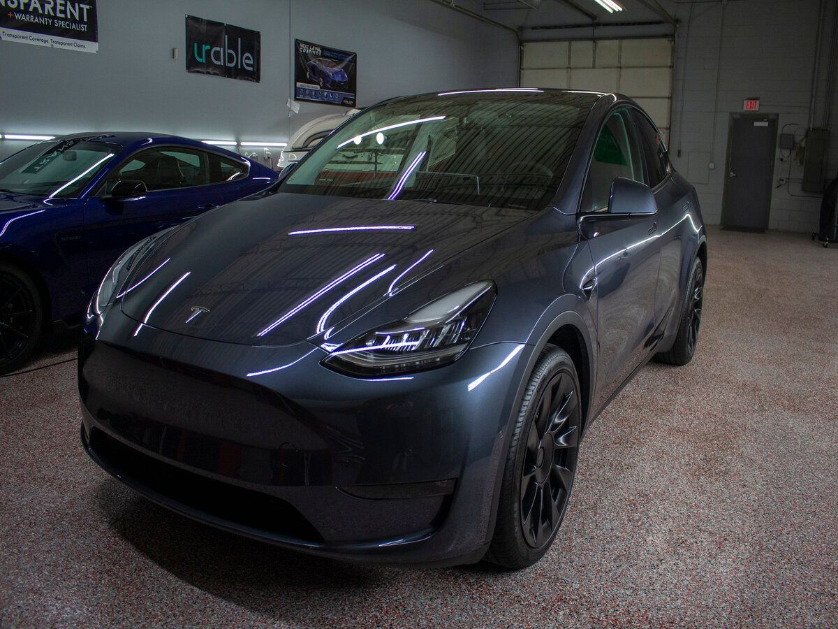 Dark gray Tesla Model Y car parked indoors.