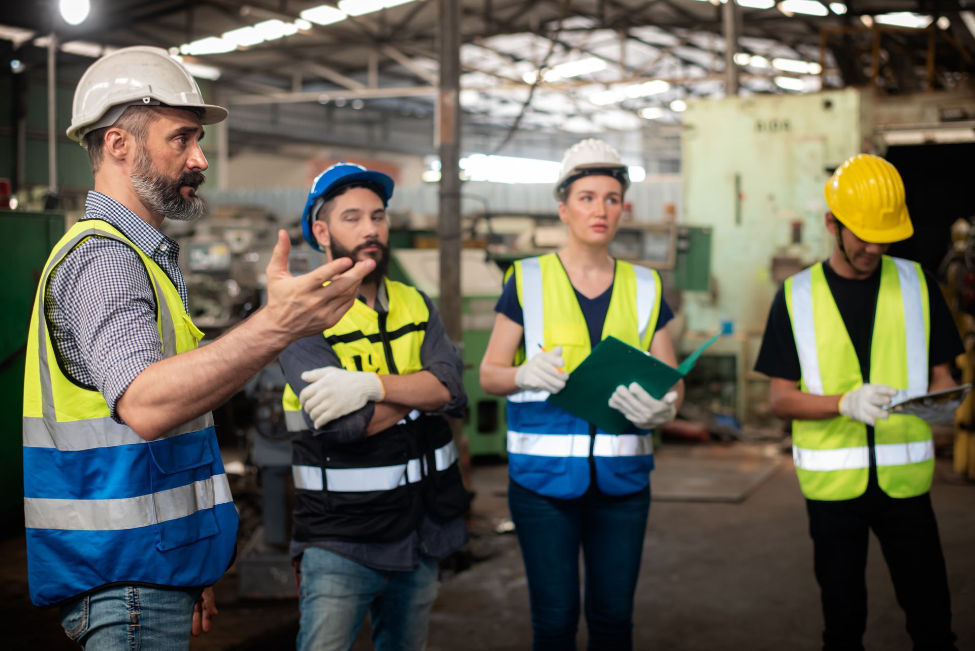 Four people in safety gear, including hard hats and high-visibility vests.
