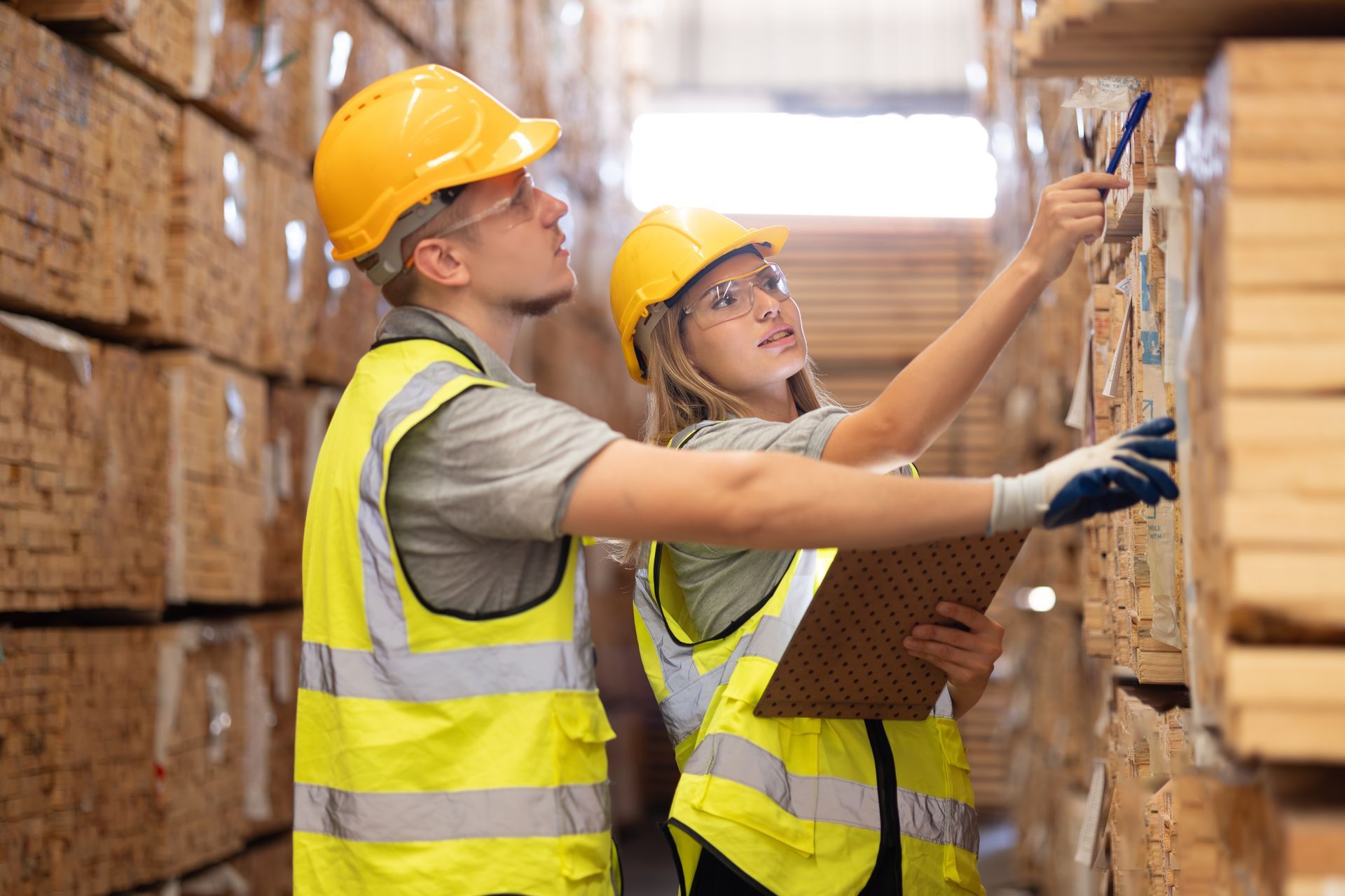 Two warehouse workers in yellow safety vests.