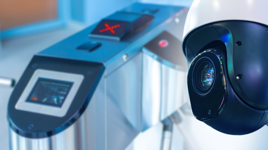 Security checkpoint scanner with a close-up surveillance camera on the right, in blue lighting