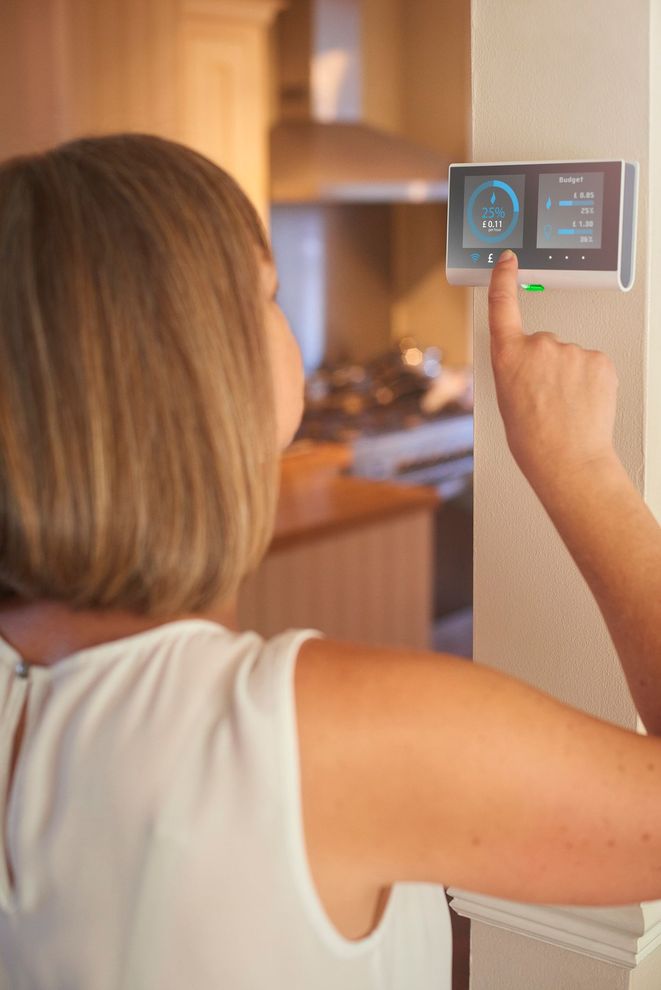 Una donna sta regolando un termostato in cucina.