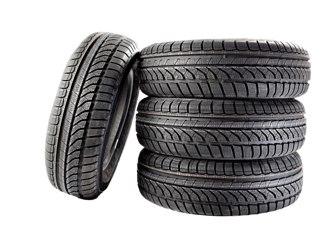 A stack of three black vehicle tires with a fourth tire standing upright next to them, isolated on a white background.